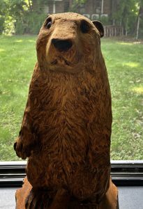 A wooden carved ground hog statute in a window.
